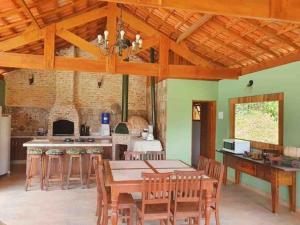 a large kitchen with a table and chairs at Chalé Heliconia in Juquitiba
