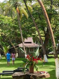 duas pessoas andando em frente a uma casa com palmeiras em Puntita Manzanillo, fantastic sea and jungle retreat em La Guayra