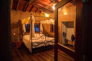 a bedroom with a canopy bed in a room at Puntita Manzanillo, fantastic sea and jungle retreat in La Guayra