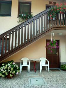 a patio with two chairs and a table under a staircase at Počitniško stanovanje Aurora in Bovec