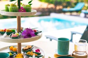 una bandeja de comida en una mesa junto a una piscina en ORCHID LODGE SAMUI - Bed & Breakfast en Lamai Beach
