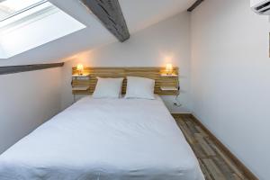 1 dormitorio con 1 cama blanca grande y 2 almohadas en Centre Historique - FREE Parking - Self Checkin - WIFI - LA CABANE - SLEEPNTRIPBEZIERS en Béziers