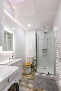 een witte badkamer met een douche en een toilet bij Centre Historique - FREE Parking - Self Checkin - WIFI - LA CABANE - SLEEPNTRIPBEZIERS in Béziers