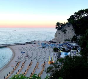 a beach with chairs and umbrellas and the ocean at Agriturismo Sentiero delle Fiabe in Sirolo