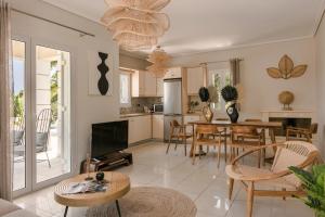 Il comprend une cuisine et un salon avec une table et des chaises. dans l'établissement Sea View Villa Kefaloniaprivatevillas, à Karavádhos