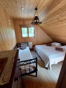 a bedroom with two beds in a wooden cabin at Bieszczadzkie Marzenie in Wetlina