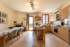 a kitchen with a table and some chairs and a counter at Villa Degli Olivi is located in Saragano in Saragano
