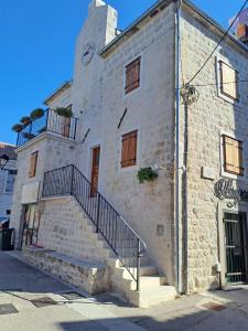 a stone building with stairs on the side of it at Val in Kaštela