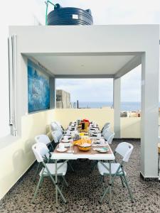 ein Esszimmer mit einem langen Tisch und weißen Stühlen in der Unterkunft Casa BB&Djassi in Ponta do Sol