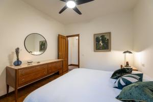a bedroom with a bed and a mirror and a dresser at Villa Degli Olivi is located in Saragano in Saragano