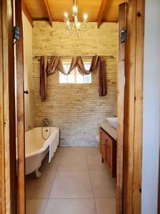 baño grande con bañera y ventana en Saxon Park Farm Cottage en Ficksburg