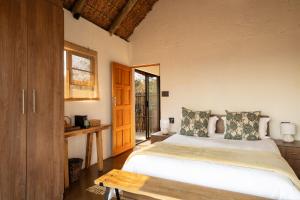 a bedroom with a large bed and a table at Elephants Crossing in Welgevonden Game Reserve