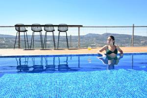 a woman standing in a swimming pool with a drink at פסגת גן עדן בחרמון in Majdal Shams