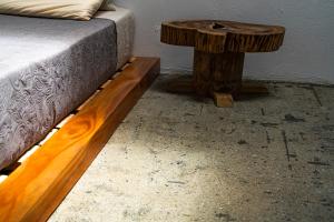 a bed with a wooden table next to a bed with a bedskirts at Aldea Sabatinga in Manizales