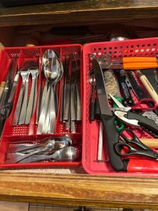 a red container filled with utensils on a drawer at logement entier: appartement. Chez Gilbert Crans-Montana in Crans-Montana