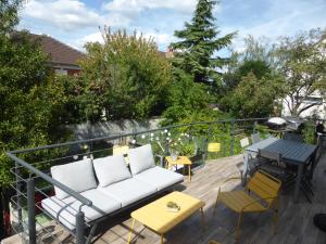 a balcony with a couch and a table and chairs at LA MARNE TRANQUILLE in Le Perreux-Sur-Marne