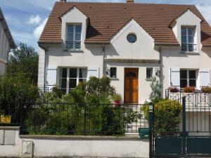 a white house with a black fence at LA MARNE TRANQUILLE in Le Perreux-Sur-Marne