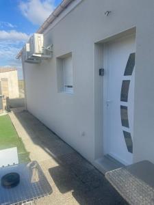 a white building with a door on the side of it at logement in Angliers