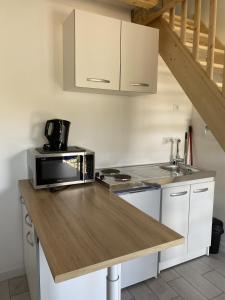 a kitchen with a counter with a microwave and a sink at logement in Angliers