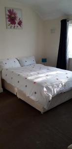 a bedroom with a bed with a flower on it at Green Village Guest House - Near Manchester Airport in Sale