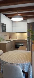 a kitchen with a table and chairs and a kitchen with white cabinets at Altxabi Apartamento Rural in Ochagavía