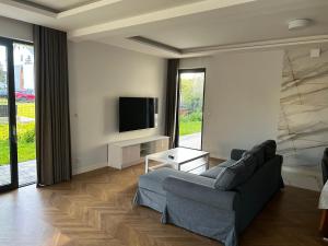 a living room with a couch and a tv at Sea Resort 1 & Spa in Władysławowo