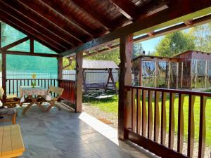 a screened porch with a table and a swing at Pensiunea Agroturistica Matis in Râșca