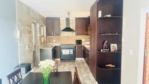 a kitchen with a table and a stove at Kuhle's Guest House in Richards Bay