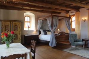 ein Schlafzimmer mit einem Himmelbett und einem Tisch in der Unterkunft Domherrenhaus Meissen in Meißen