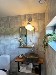 a bathroom with a sink and a mirror at Boutiquehotell Dahlbogården in Alingsås