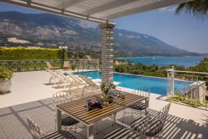 une terrasse avec une table, des chaises et une piscine dans l'établissement Sea View Villa Kefaloniaprivatevillas, à Karavádhos