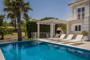 - une piscine avec des chaises longues à côté d'une maison dans l'établissement Sea View Villa Kefaloniaprivatevillas, à Karavádhos