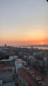 a view of a city with the sunset in the background at Apartamento céntrico y moderno con vistas a la Ría in Vigo