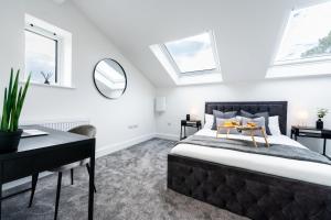 a bedroom with a bed and a desk and windows at Hosta Group - Prestige 1 Bed Apartment - The Lemon in Cambridge