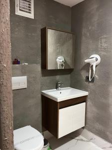 y baño con lavabo, aseo y espejo. en Olen Uskudar Hotel en Estambul