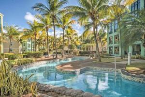 a pool with palm trees in front of a building at Aquatika 2303 in Loiza