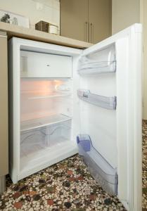 an empty refrigerator with its door open in a kitchen at Sonnenhaus in Olympic Beach