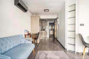 a living room with a blue couch and a kitchen at Great location in Besiktas/Akaretler in Istanbul