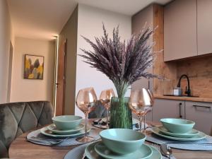 a dining room table with plates and wine glasses at Samanų apartamentai in Šiauliai +19 photos