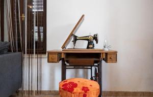 una máquina de coser sentada en una mesa junto a un taburete en Apartment Tea en Preko