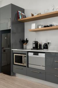 a kitchen with a stove and a microwave at Luxury Franschhoek getaway next to Winetram in Franschhoek