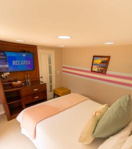 1 dormitorio con 1 cama y TV en la pared en Hotel Mansión Barichara en Barichara