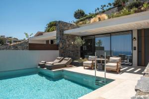 een huis met een zwembad naast een huis bij Happy Cretan Suites in Agia Pelagia