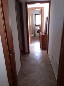 un corridoio di una casa con una camera con pavimento piastrellato di casa vacanza Green House Casalvelino a Omignano Scale