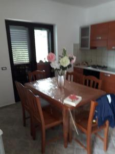 tavolo da pranzo con vaso di fiori di casa vacanza Green House Casalvelino a Omignano Scale