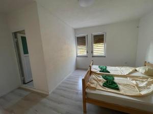 a bedroom with a bed and two windows at Rock Hostel in Pristina
