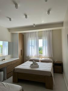 een slaapkamer met een groot bed en een raam bij Suit Apartment Golem, Durres in Golem