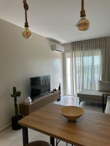 a living room with a flat screen tv and a table at Suit Apartment Golem, Durres in Golem