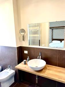 a bathroom with a sink and a toilet and a mirror at TorreNormanna Prestige House near Cefalù in Mandra Capreria