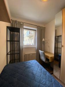 1 dormitorio con cama, escritorio y ventana en Apartament Słowackiego 29 en Gdansk